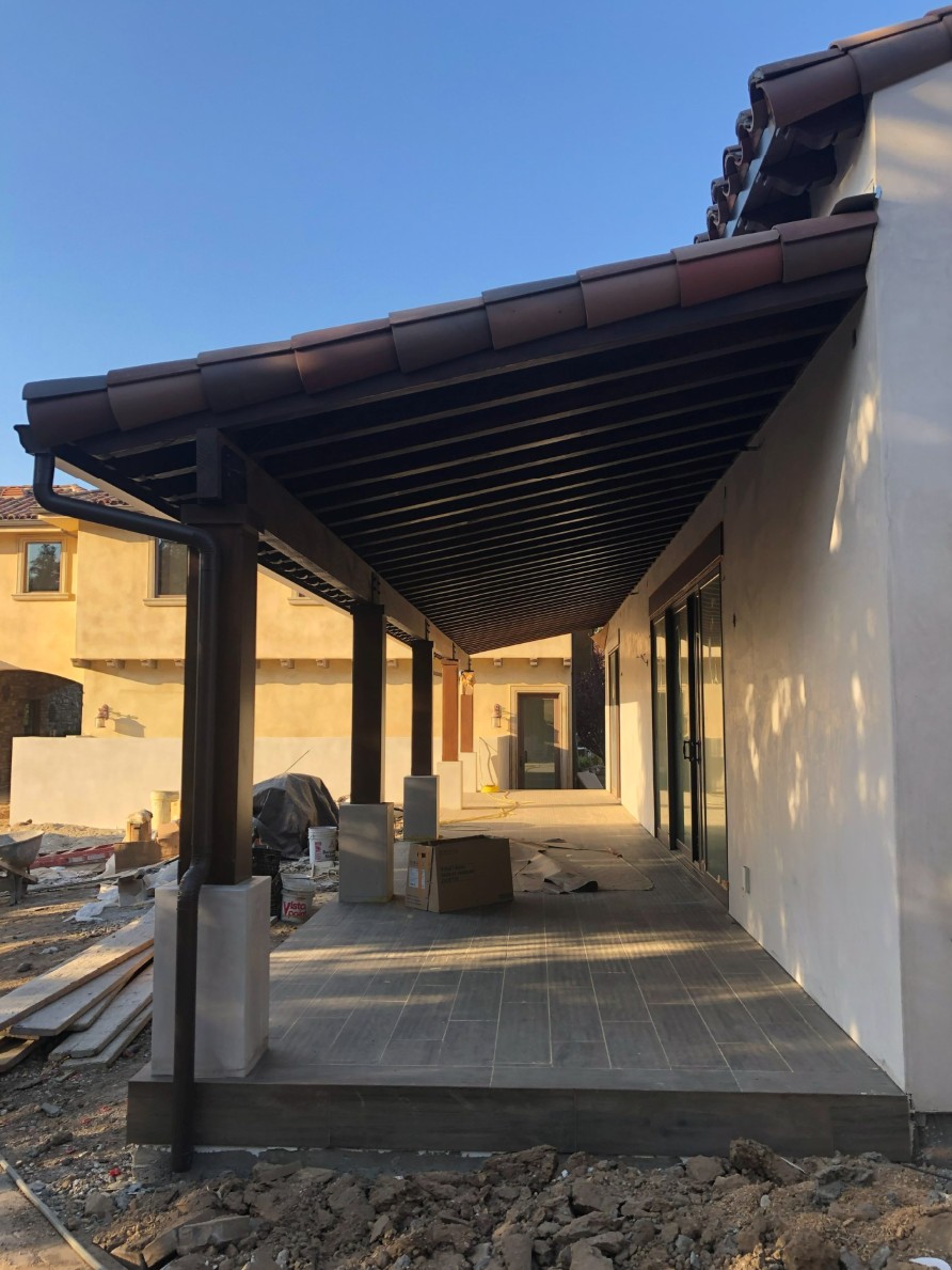 Covered ADU terrace under construction with timber framing and tiled floor