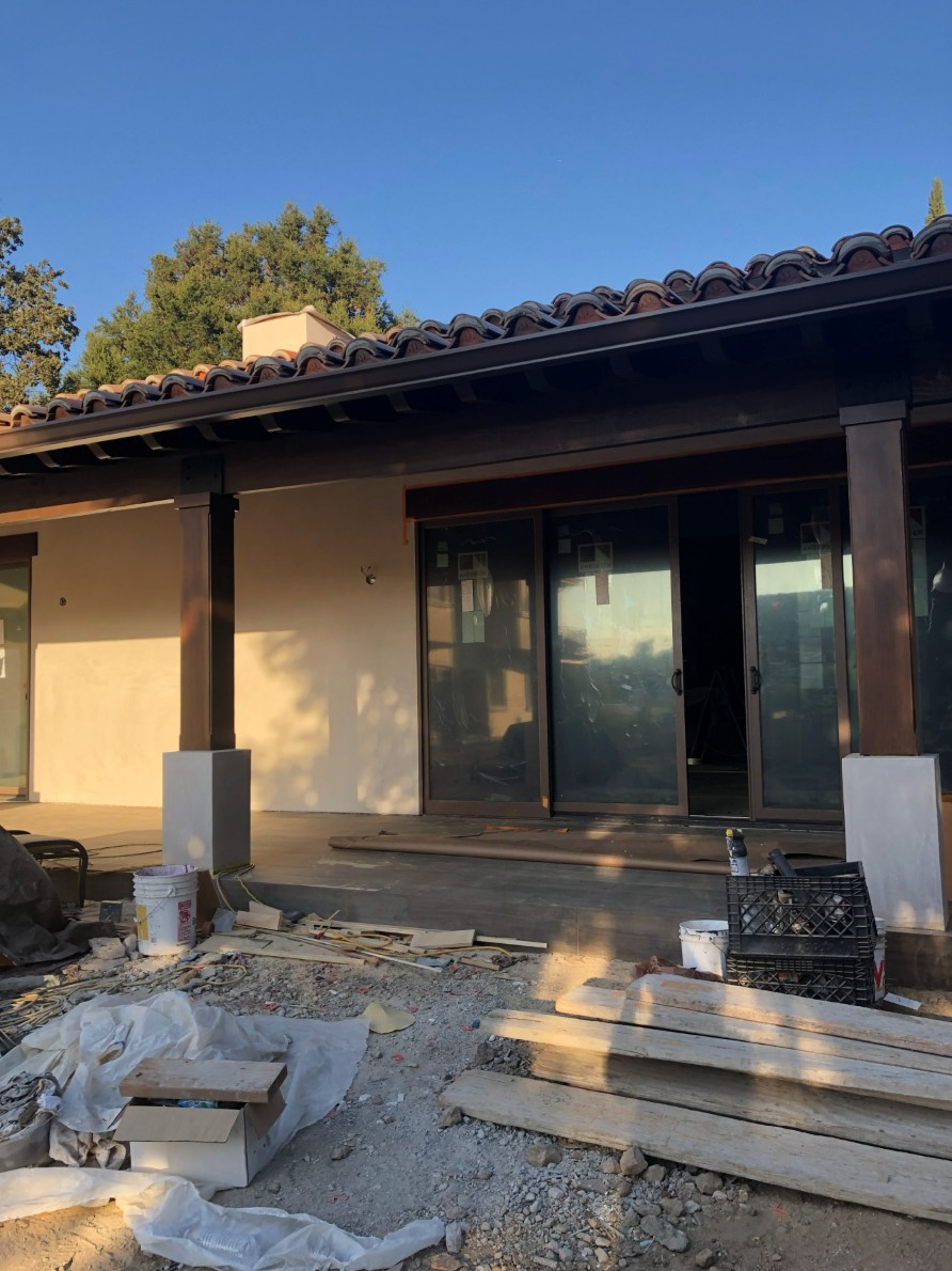 Close construction view of the ADU covered terrace, timber posts, and steel doors