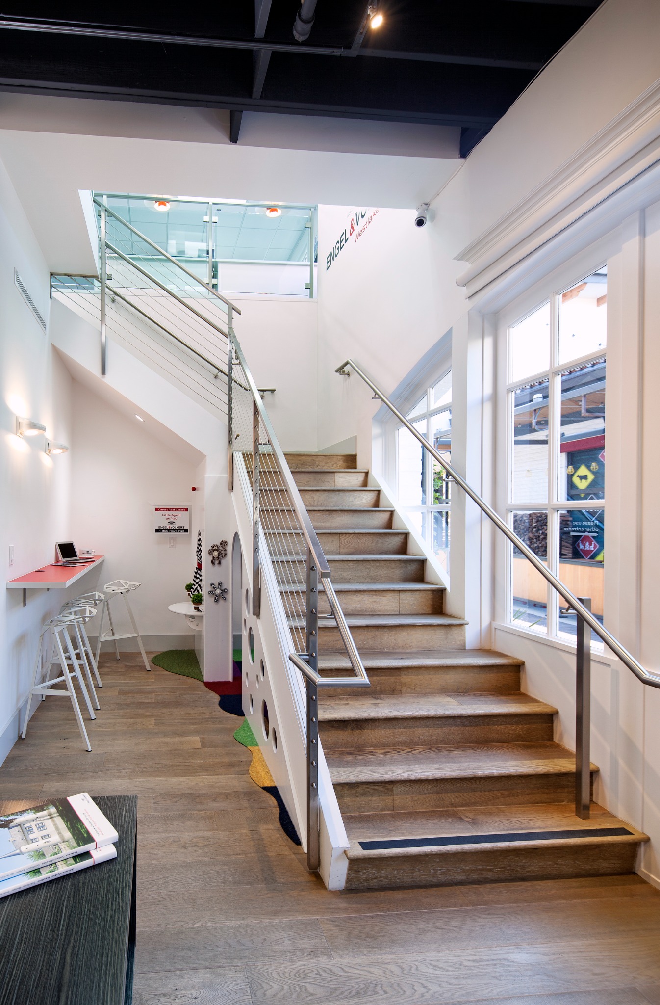 Feature stair at the Engel & Völkers office with wood treads, cable railings, and glass guards