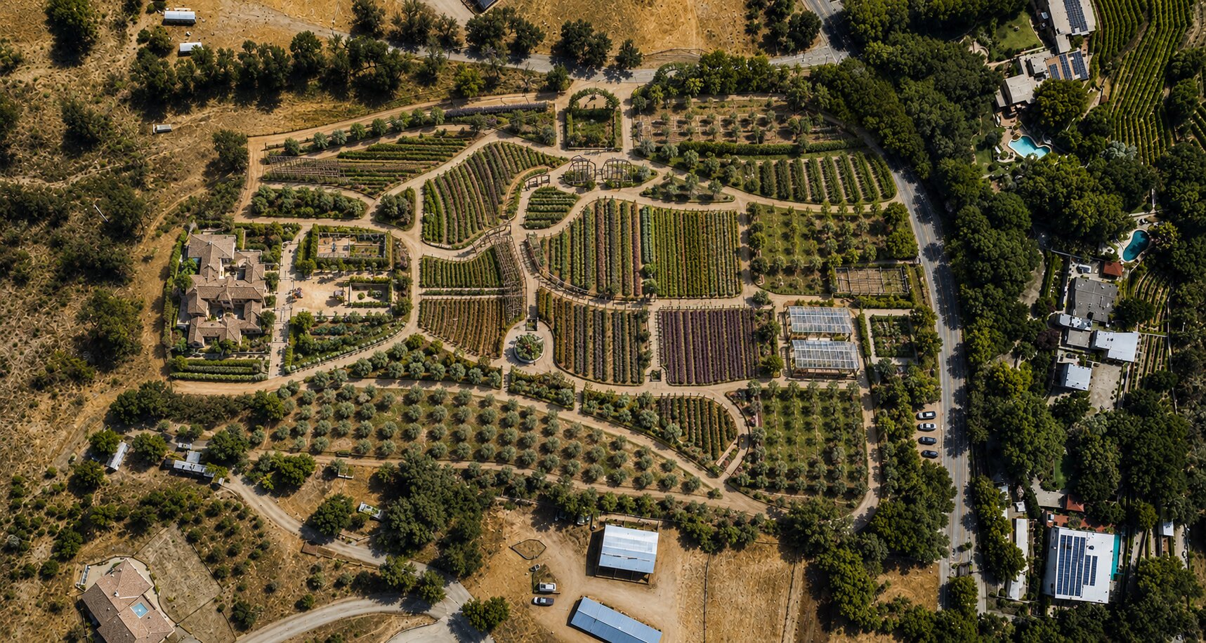 Aerial view of a homestead with fields, gardens, and estate buildings