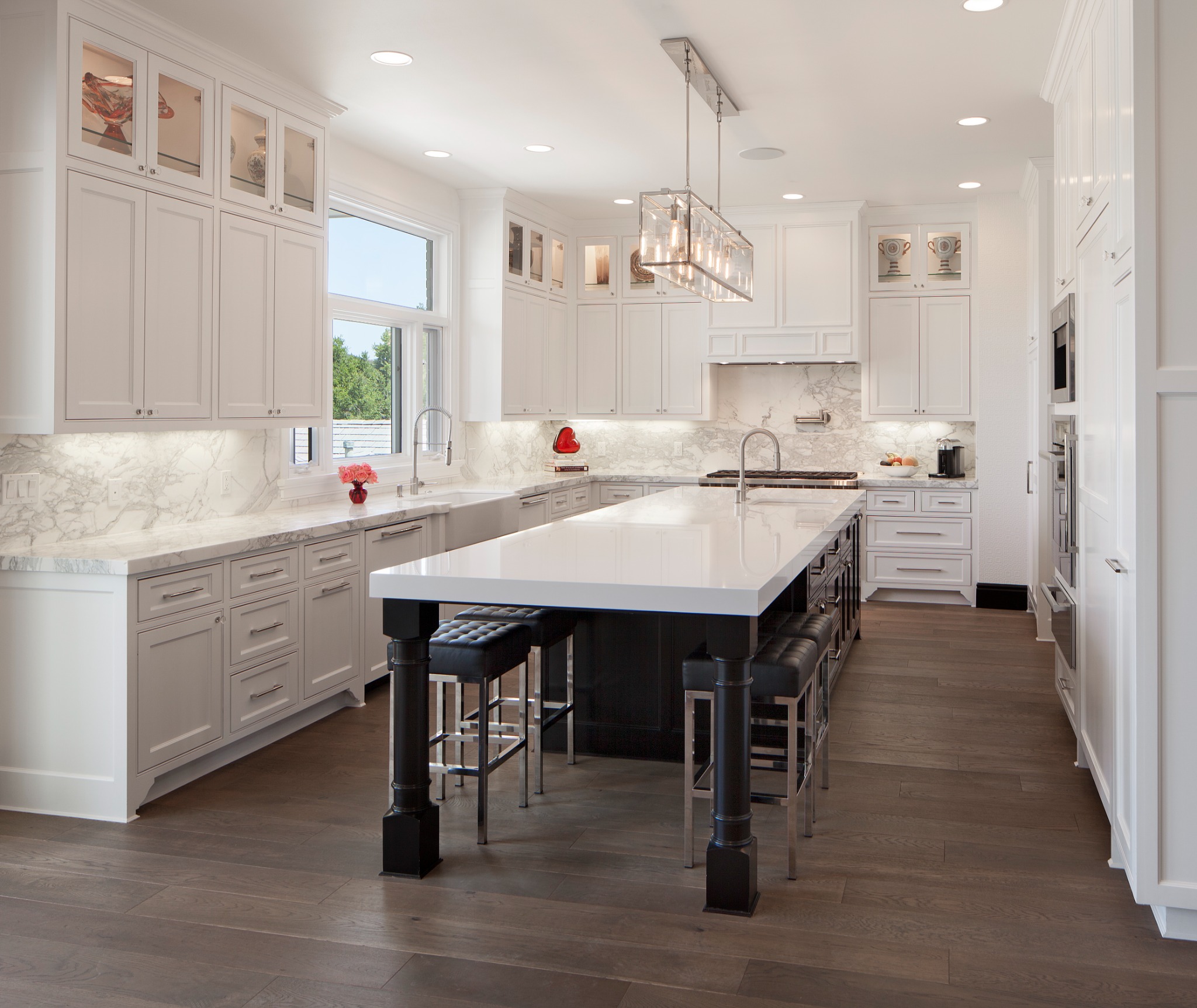 Garden Estate custom kitchen with white cabinetry, marble surfaces, and a dark island